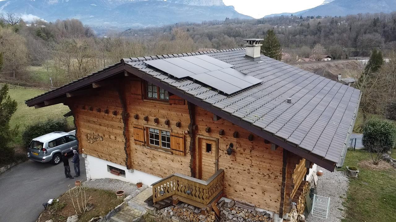 Installation de 7 panneaux photovoltaïques bi-verre sur le toit d'un chalet en madrier à Saint-Pierre en Faucigny en Haute-Savoie